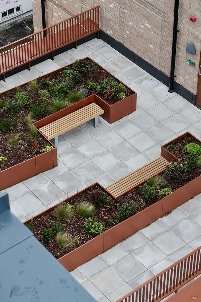 Paved roof terrace with planters and benches